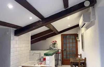 a kitchen with white walls and wooden beams at Garibaldi mansardé in Nice