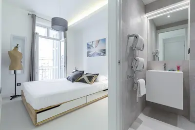 a white bedroom with a bed and a sink at DALPOZZO HYPER CENTRE PROCHE MER in Nice