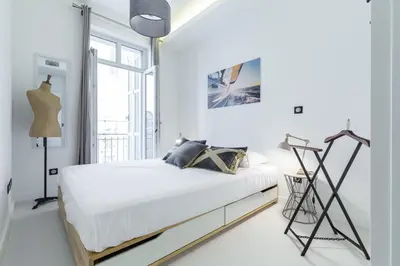 a white bedroom with a bed and a window at DALPOZZO HYPER CENTRE PROCHE MER in Nice