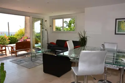 a living room with a glass table and a couch at Villa ZEN in Saint-Laurent-du-Var