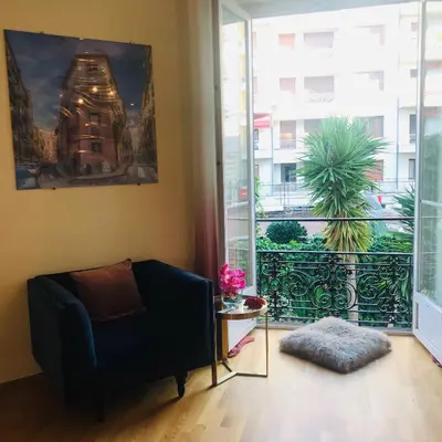 a living room with a couch and a large window at Nice Apartment Roses & Ivy, Rue du Congres in Nice