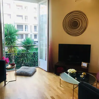 a living room with a television and a large window at Nice Apartment Roses & Ivy, Rue du Congres in Nice