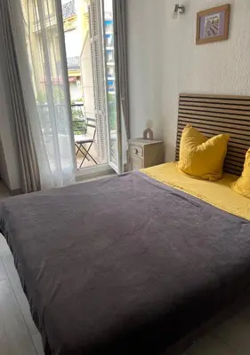 a bedroom with a large bed with a large window at Chez Eva in Nice