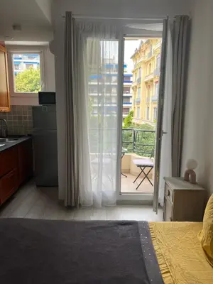a bedroom with a door open to a balcony at Chez Eva in Nice