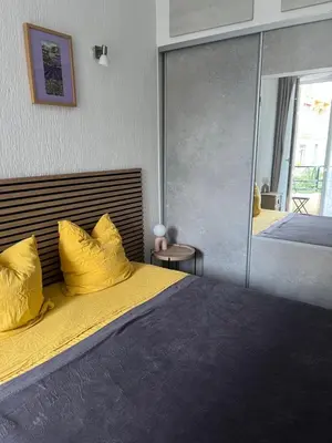 a bedroom with a bed with yellow pillows and a mirror at Chez Eva in Nice