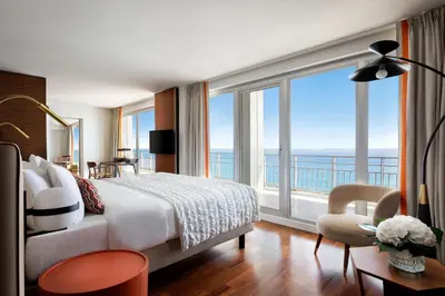 a bedroom with a bed and a large window at Le Meridien Nice in Nice