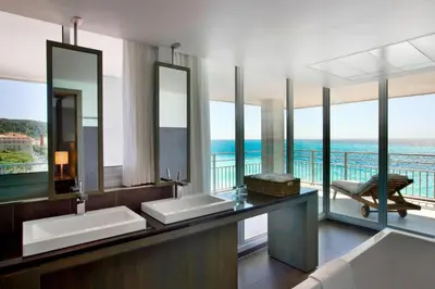 a bathroom with two sinks and a view of the ocean at Le Meridien Nice in Nice