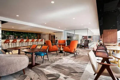 a hotel lobby with tables and chairs and a bar at Le Meridien Nice in Nice