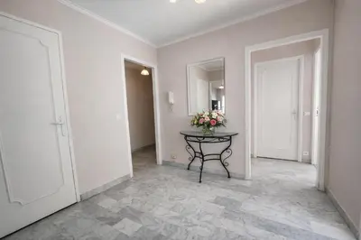 a hallway with a table with flowers on it at Port, vue mer et confort et parking in Nice