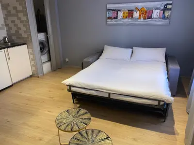a large bed in a room with two tables at STUDIO VIEILLE VILLE in Nice