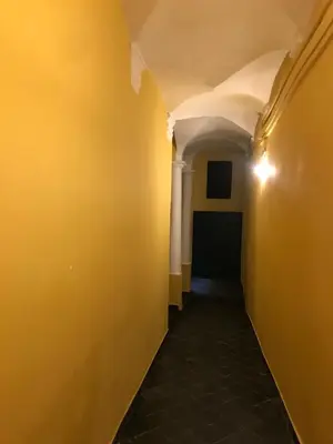 an empty hallway with yellow walls and a black floor at STUDIO VIEILLE VILLE in Nice