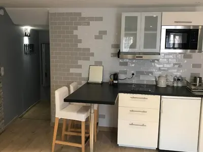 a kitchen with white cabinets and a black counter top at STUDIO VIEILLE VILLE in Nice