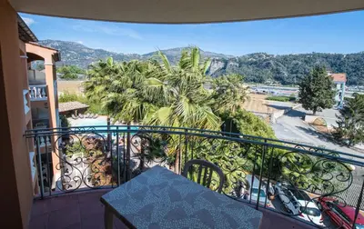 a balcony with a view of a palm tree at Appart Hotel Lou Castelet in Carros