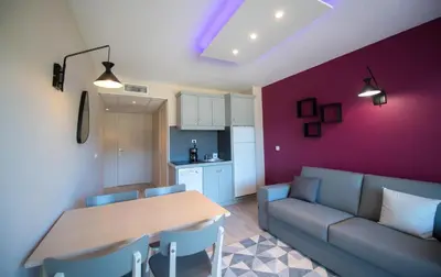 a living room with a couch and a table at Appart Hotel Lou Castelet in Carros