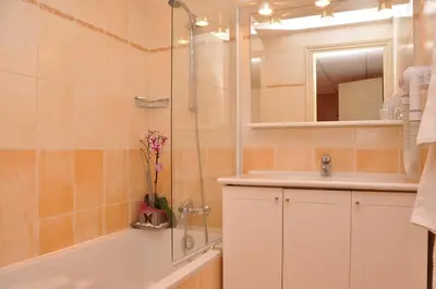 a bathroom with a tub and a sink and a shower at Appart Hotel Lou Castelet in Carros