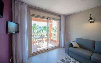 a living room with a couch and a sliding glass door at Appart Hotel Lou Castelet in Carros