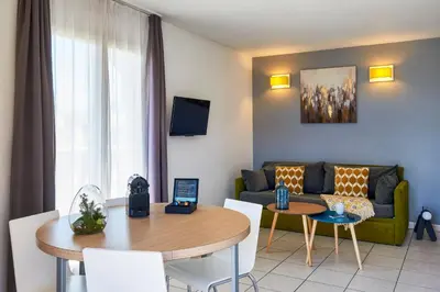 a living room with a couch and a table at Aparthotel Adagio Access Nice Magnan in Nice
