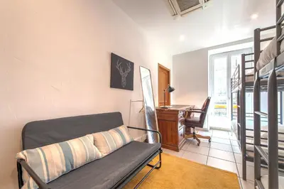 a bedroom with a bed and a desk in a room at Lovely large familial apartment in central Nice, ten minutes walk to the beach! in Nice