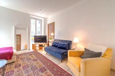 a living room with two chairs and a couch and a television at Lovely large familial apartment in central Nice, ten minutes walk to the beach! in Nice