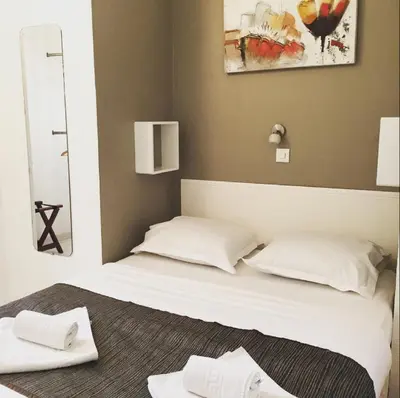 a bed with two white pillows in a room at Hotel Danemark in Nice