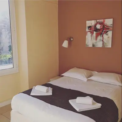 two beds in a hotel room with towels on them at Hotel Danemark in Nice