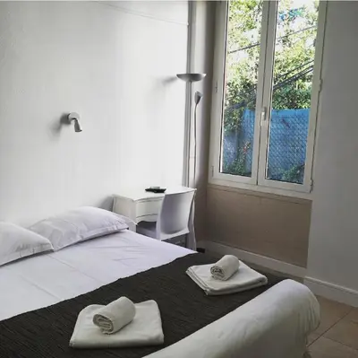 a bedroom with a large bed with towels on it at Hotel Danemark in Nice