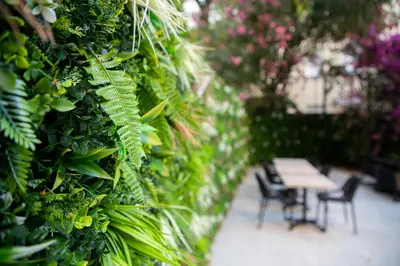 a table and chairs in a garden with plants at Hotel Saint Georges in Nice