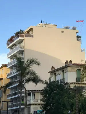 a tall building with a palm tree in front of it at LOFT 360° Nice in Nice