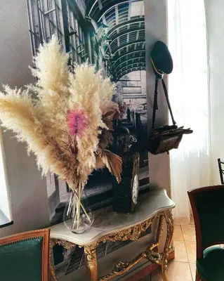 a table with a vase with feathers on it at Interlaken in Nice