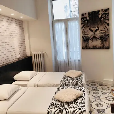 a bedroom with two beds and a picture of a tiger at Interlaken in Nice