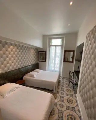 a hotel room with two beds and a table at Interlaken in Nice