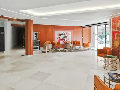 a living room with orange walls and furniture at Goldstar Apartments & Suites in Nice