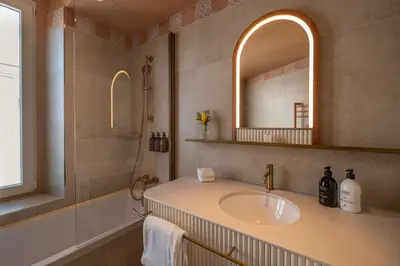 a bathroom with a sink and a mirror and a tub at Hôtel Le Soleia by Inwood Hotels in Nice