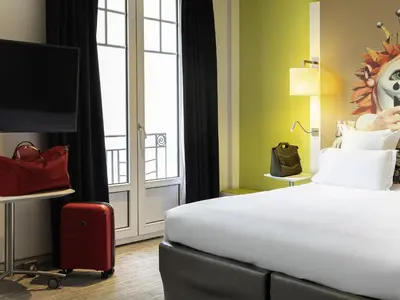 a hotel room with two beds and a tv at Mercure Nice Centre Grimaldi in Nice