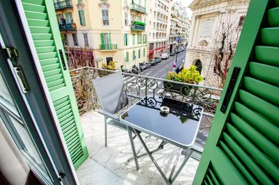 a balcony with a chair and a street at Hôtel Parisien in Nice