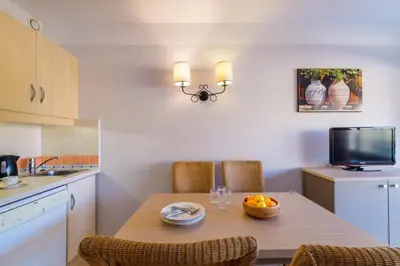 a kitchen with a table with a bowl of fruit on it at Résidence Pierre & Vacances Heliotel Marine in Saint-Laurent-du-Var