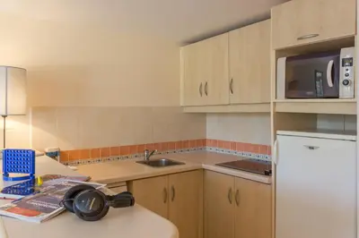 a small kitchen with a sink and a refrigerator at Résidence Pierre & Vacances Heliotel Marine in Saint-Laurent-du-Var