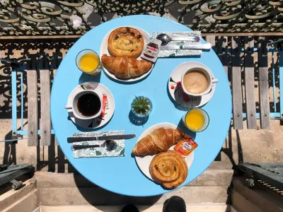 a blue table with breakfast foods and coffee on it at Hotel le Nice Etoile in Nice