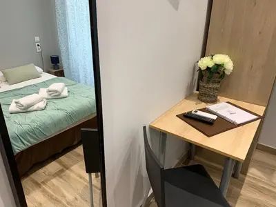 a room with a mirror and a table with a bed at Hotel le Nice Etoile in Nice