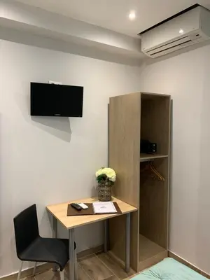 a room with a desk and a tv on a wall at Hotel le Nice Etoile in Nice