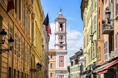 a clock tower in the middle of a street with buildings at La Rose: Charming 2-room apartment in the heart of Nice - 3-min. from the beach in Nice