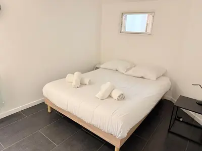 a white bed with two white towels on it at La Rose: Charming 2-room apartment in the heart of Nice - 3-min. from the beach in Nice