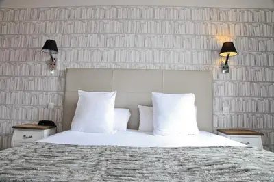 a bedroom with a bed with white sheets and pillows at Hotel La Villa Nice Victor Hugo in Nice