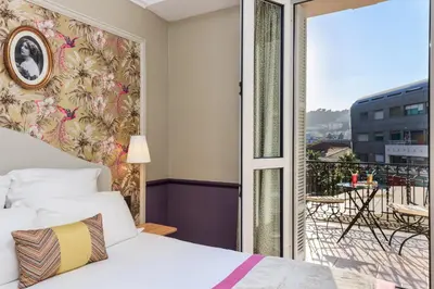 a bedroom with a bed and a balcony at Villa Otero by Happyculture in Nice