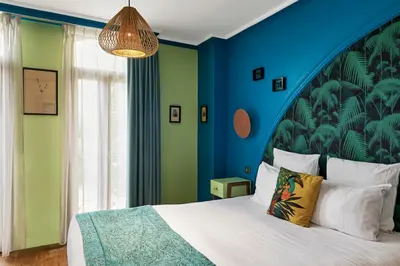 a bedroom with a large bed with a blue wall at Villa Bougainville by Happyculture in Nice