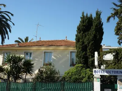 a white house with a fence in front of it at Logis Hôtel Villa Victorine in Nice