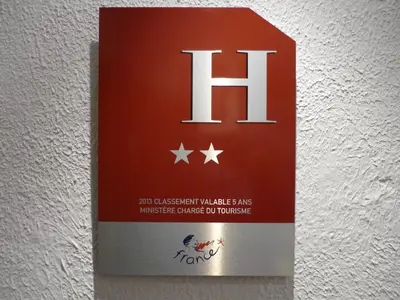 a sign on a wall with the h on it at Logis Hôtel Villa Victorine in Nice
