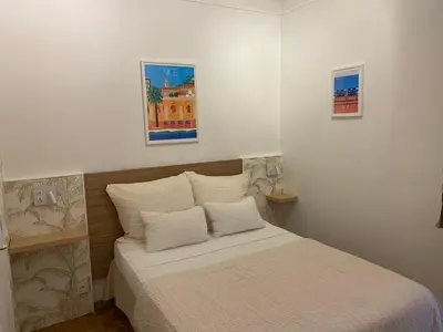 a bedroom with a white bed with pillows and a window at Logis Hôtel Villa Victorine in Nice