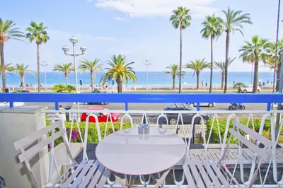 a table and chairs on a balcony overlooking the beach at PROMENADE HOLIDAY - SUFFREN BEACH in Nice