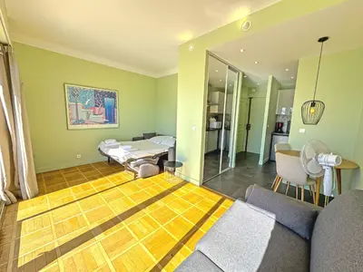 a living room with a couch and a mirror at PROMENADE HOLIDAY - SUFFREN BEACH in Nice